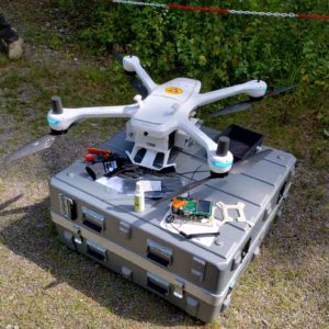 A drone with equipment on top of its container outdoors