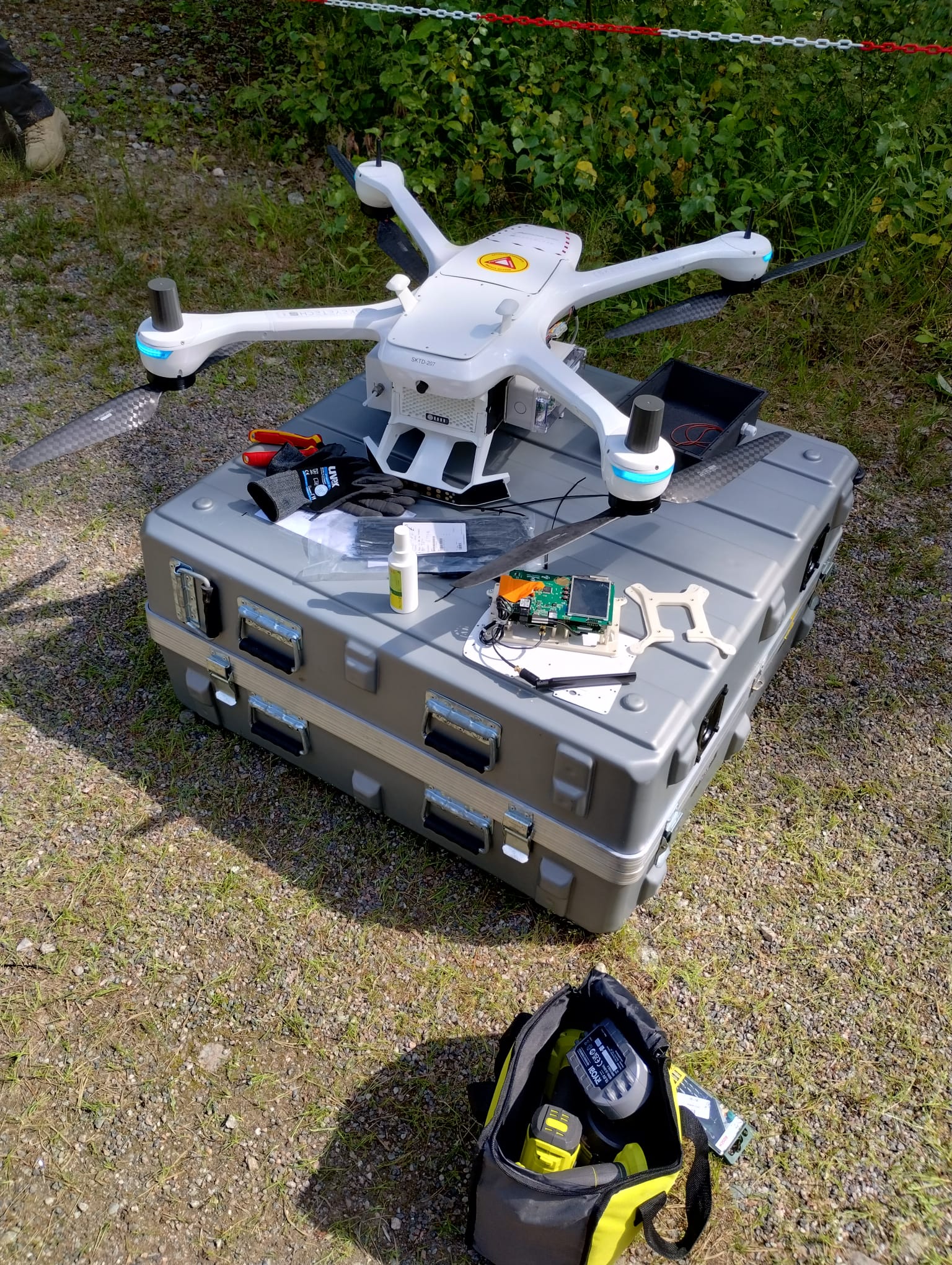 A drone with equipment on top of its container outdoors